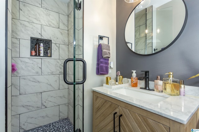 bathroom featuring a shower with door and vanity