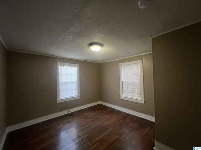 spare room featuring ornamental molding, a textured ceiling, and dark wood-type flooring