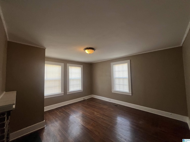 unfurnished room featuring dark wood-type flooring and ornamental molding