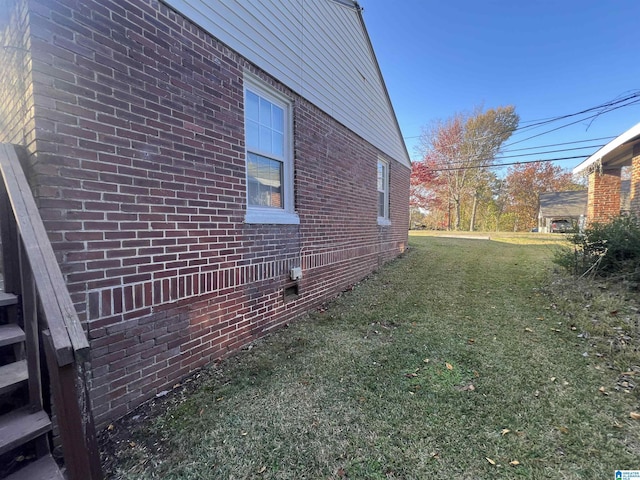 view of side of home with a yard