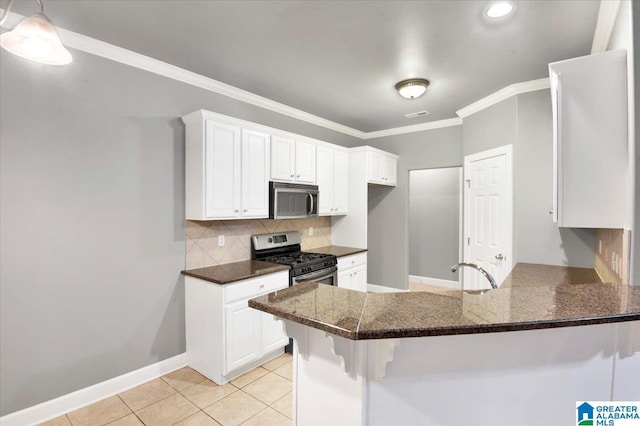 kitchen with kitchen peninsula, white cabinets, light tile patterned floors, and appliances with stainless steel finishes