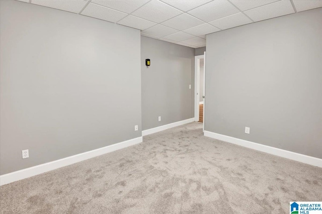 carpeted empty room with a drop ceiling