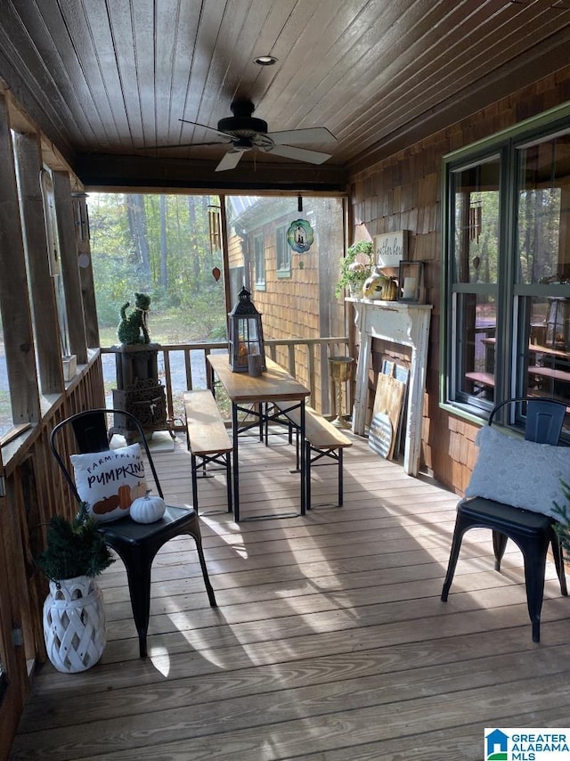 sunroom with a healthy amount of sunlight, ceiling fan, and wooden ceiling