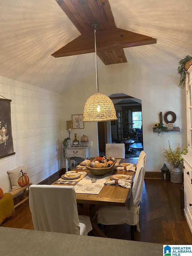 dining space with vaulted ceiling with beams and dark hardwood / wood-style floors