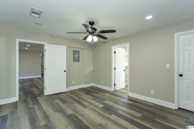 unfurnished room featuring electric panel, ceiling fan, and dark hardwood / wood-style floors