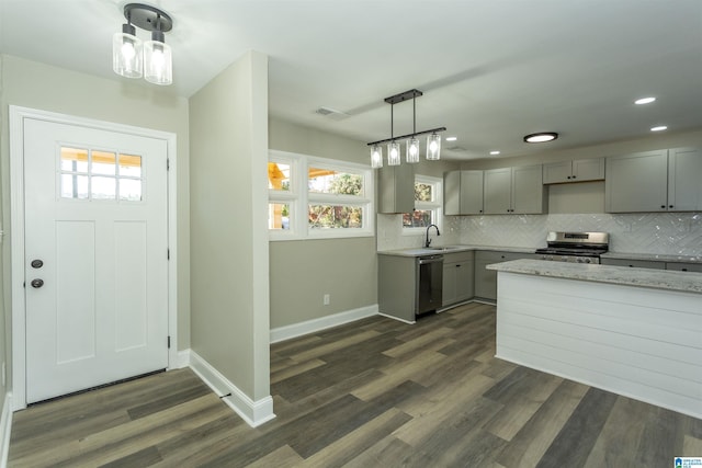 kitchen featuring pendant lighting, sink, gray cabinets, dark hardwood / wood-style flooring, and stainless steel appliances