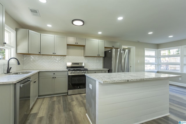 kitchen featuring light stone countertops, stainless steel appliances, dark wood-type flooring, and sink