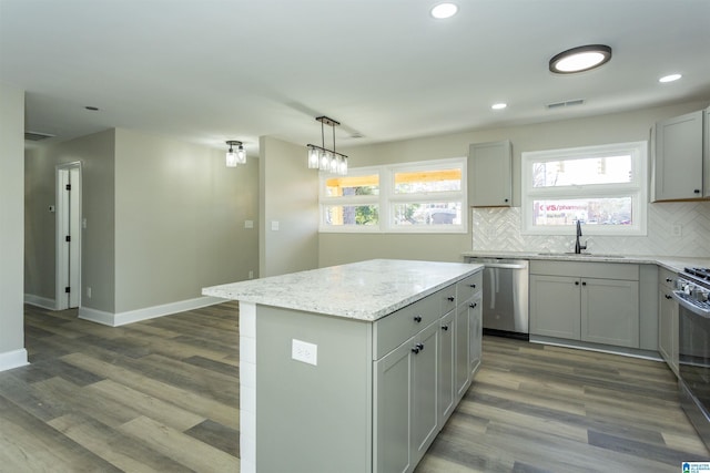 kitchen with dishwasher, sink, hanging light fixtures, dark hardwood / wood-style floors, and a kitchen island