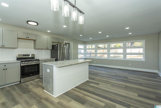 kitchen with appliances with stainless steel finishes, dark hardwood / wood-style flooring, light stone counters, gray cabinetry, and decorative light fixtures