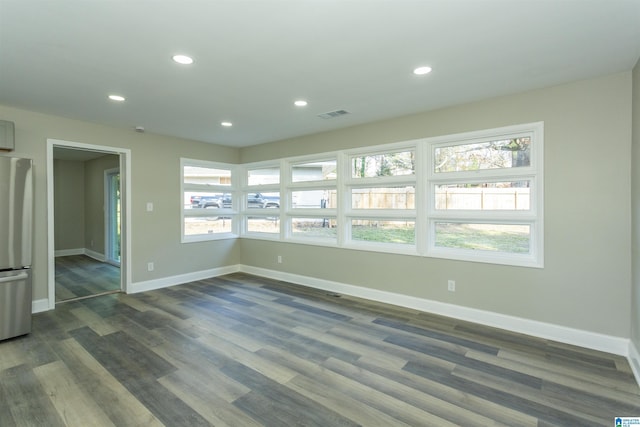 unfurnished room featuring dark hardwood / wood-style floors and plenty of natural light