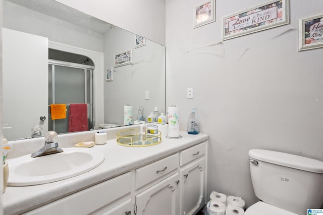 bathroom with vanity, toilet, and an enclosed shower