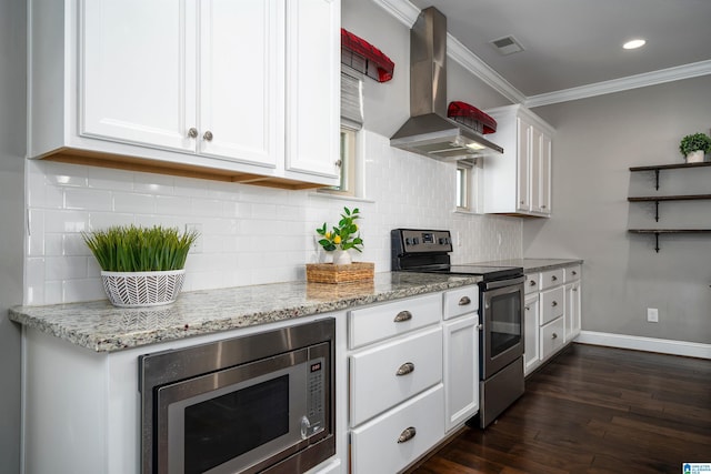 kitchen with appliances with stainless steel finishes, crown molding, dark wood-type flooring, white cabinetry, and range hood