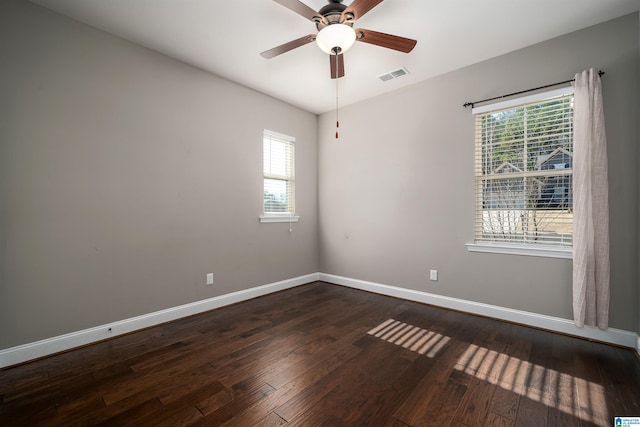 empty room with ceiling fan and dark wood-type flooring