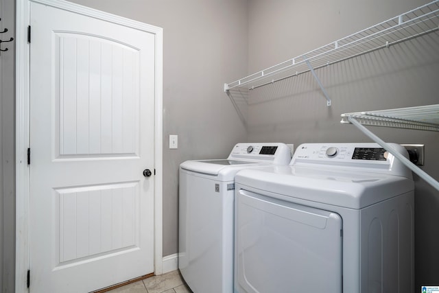 laundry room with washing machine and dryer and light tile patterned floors