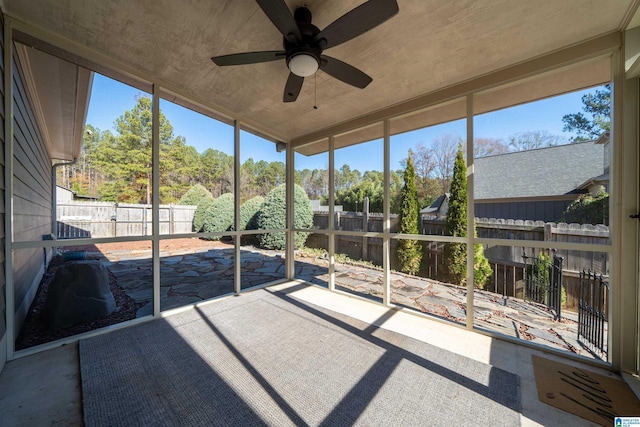 unfurnished sunroom featuring ceiling fan