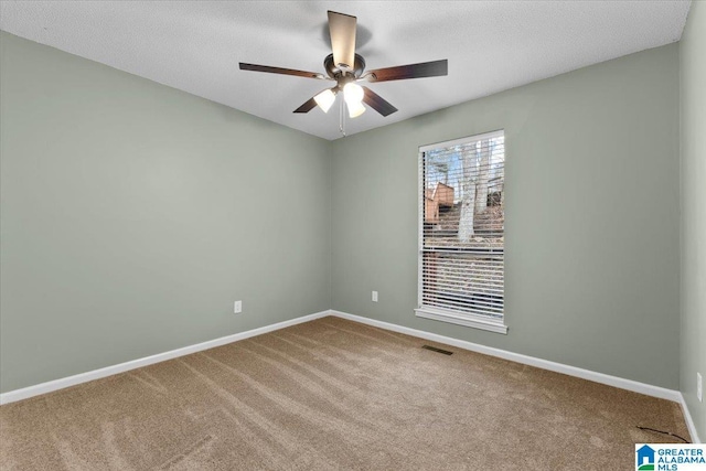 carpeted spare room featuring ceiling fan and a textured ceiling