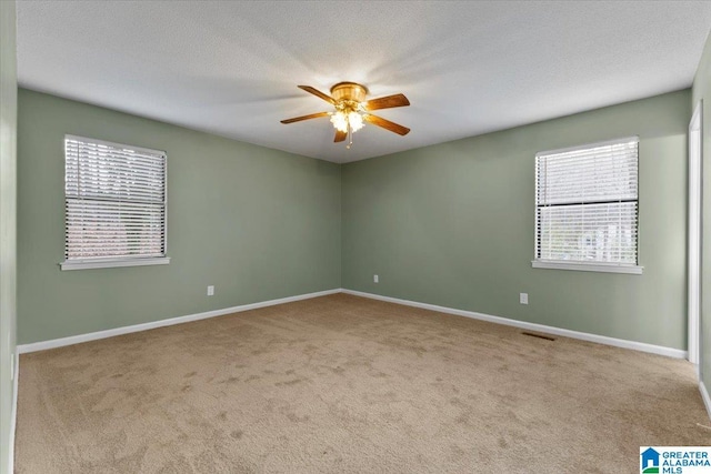 carpeted empty room featuring a textured ceiling and ceiling fan