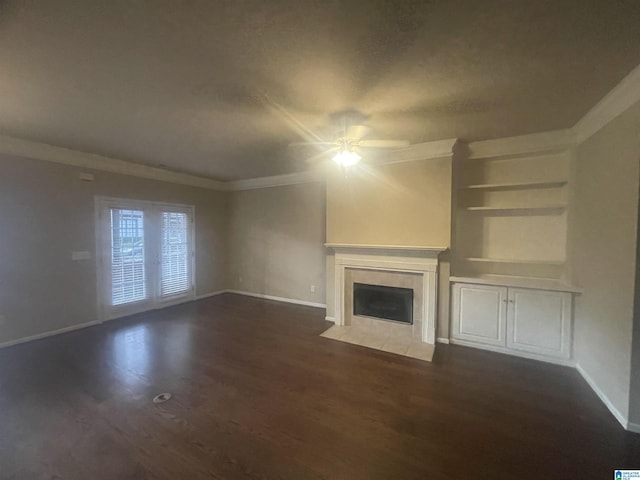 unfurnished living room featuring a tile fireplace, dark hardwood / wood-style floors, ceiling fan, and ornamental molding