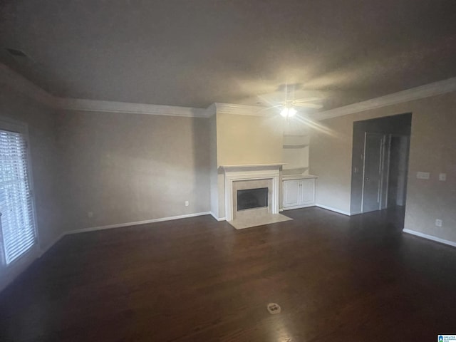 unfurnished living room with ceiling fan, dark hardwood / wood-style flooring, and crown molding