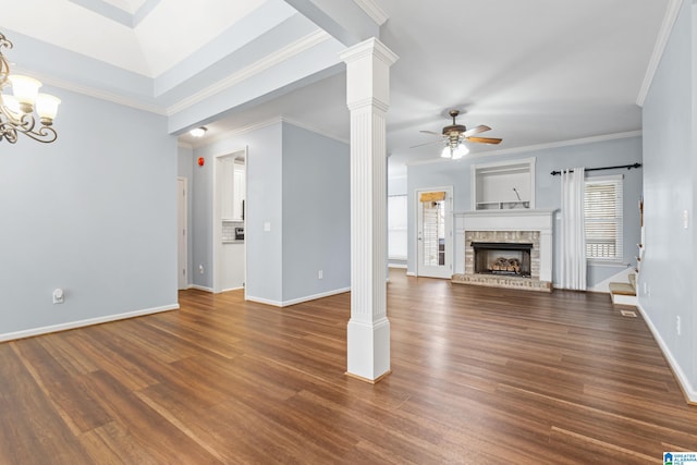 unfurnished living room featuring decorative columns, ceiling fan with notable chandelier, crown molding, and dark hardwood / wood-style floors