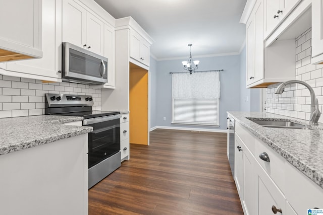 kitchen with decorative light fixtures, sink, white cabinets, and stainless steel appliances