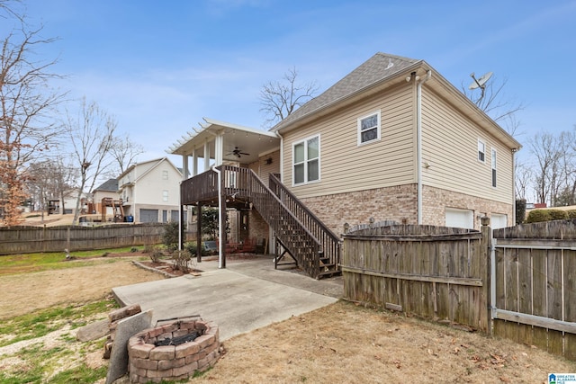 rear view of property featuring a patio area, an outdoor fire pit, a wooden deck, and ceiling fan