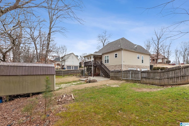 rear view of house featuring a storage unit, a deck, and a lawn