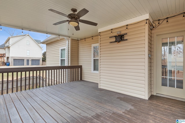 deck with a garage and ceiling fan