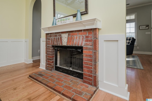 details with a brick fireplace, hardwood / wood-style flooring, and ornamental molding