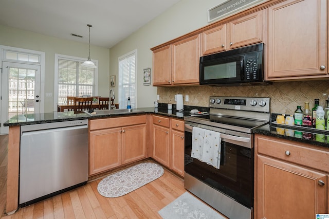 kitchen featuring tasteful backsplash, kitchen peninsula, sink, and appliances with stainless steel finishes