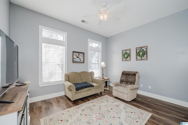 living area featuring dark hardwood / wood-style floors and ceiling fan