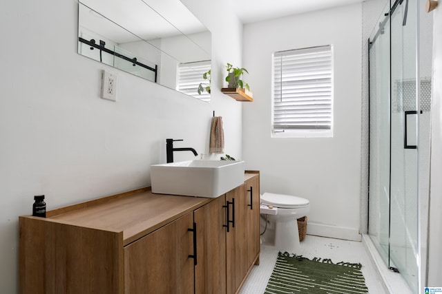 bathroom featuring vanity, toilet, and a shower with door