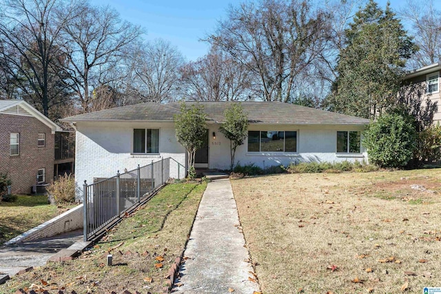 ranch-style house featuring a front lawn and cooling unit