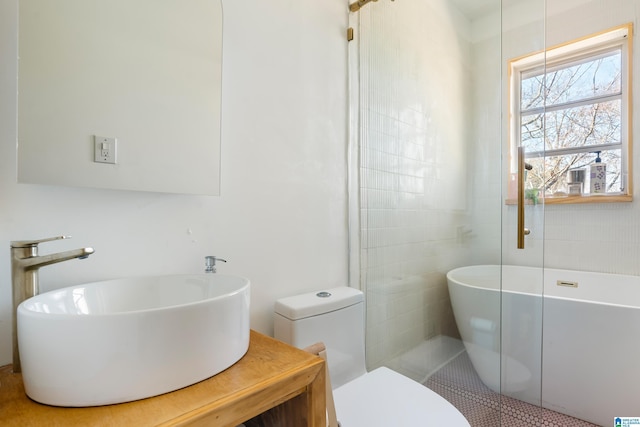 bathroom with tile patterned floors, a washtub, toilet, and sink