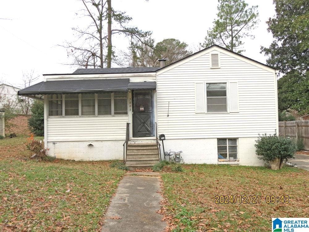 view of front of property featuring a sunroom and a front yard