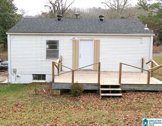 rear view of house featuring a wooden deck and a shingled roof