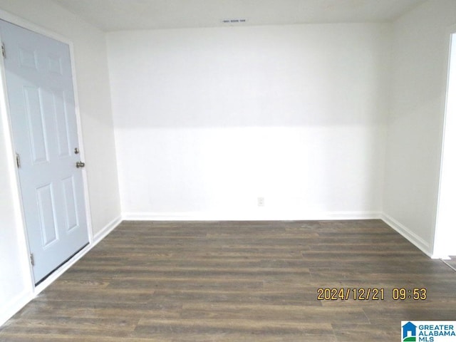 spare room featuring visible vents, baseboards, and wood finished floors