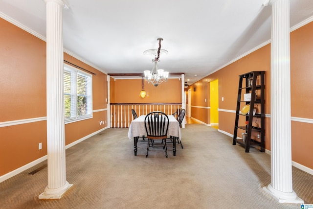 carpeted dining room featuring decorative columns, an inviting chandelier, and ornamental molding