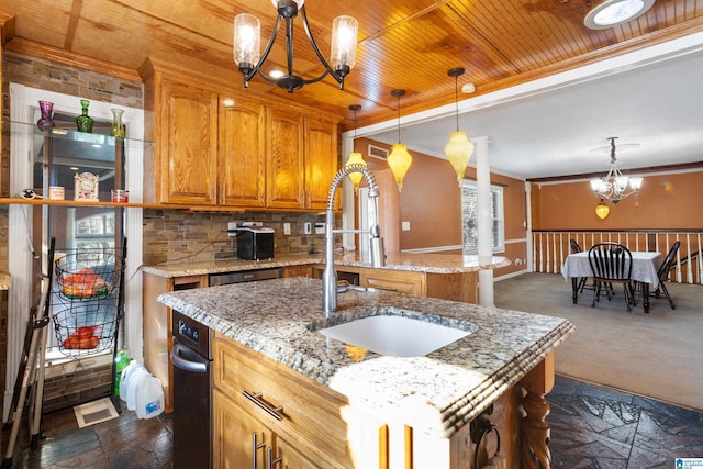 kitchen featuring a kitchen island with sink, crown molding, sink, decorative light fixtures, and a notable chandelier