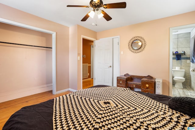 bedroom with connected bathroom, ceiling fan, a closet, and hardwood / wood-style flooring