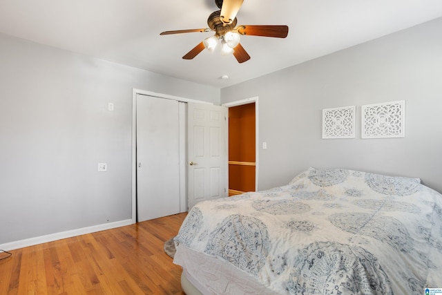 bedroom with ceiling fan, a closet, and wood-type flooring