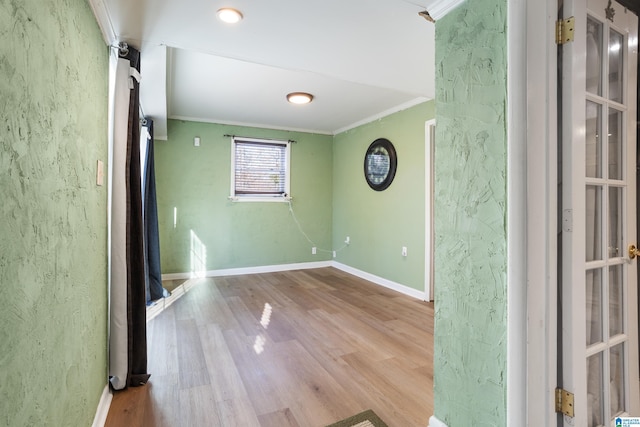 unfurnished room featuring light wood-type flooring and crown molding