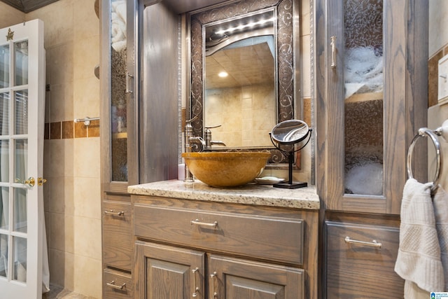 bathroom featuring vanity and tile walls