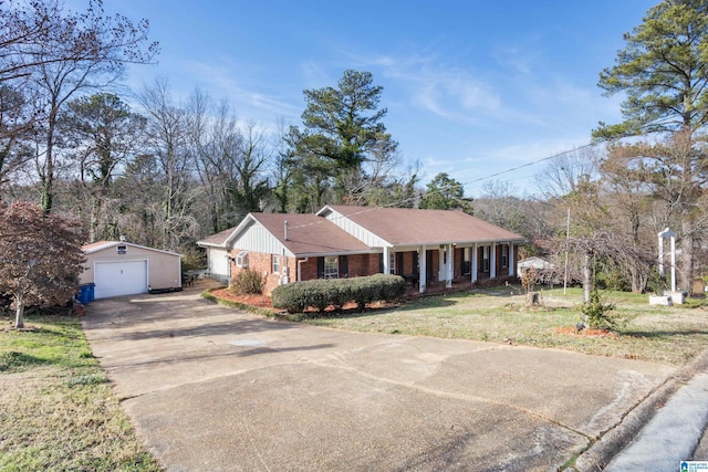 ranch-style house with covered porch, a garage, an outbuilding, and a front lawn