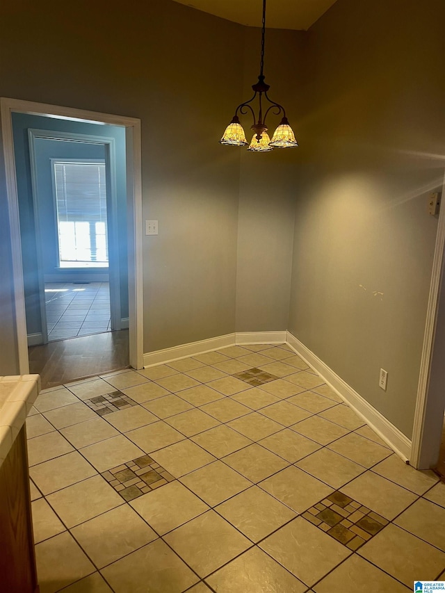 unfurnished dining area with light tile patterned floors and a chandelier