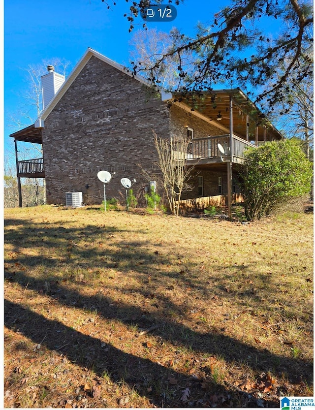 view of side of home featuring central air condition unit, a yard, and a deck