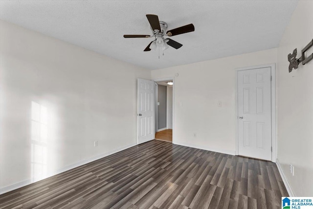 empty room featuring dark wood-type flooring, a ceiling fan, baseboards, and a textured ceiling