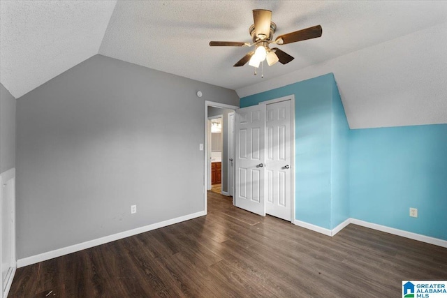 bonus room featuring a textured ceiling, dark hardwood / wood-style floors, ceiling fan, and lofted ceiling