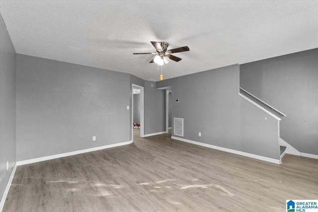 unfurnished living room with ceiling fan, light hardwood / wood-style floors, and a textured ceiling