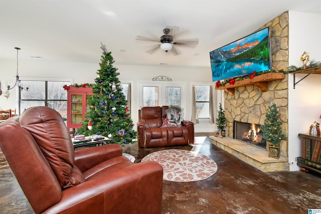 living room with ceiling fan, concrete flooring, and a fireplace